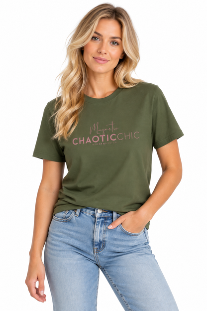 A woman modeling a green graphic T-shirt with pink text reading 'Magnetic Chaotic Chic', paired with light-wash blue jeans against a plain white background.