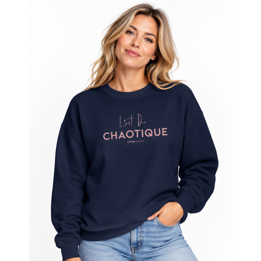 A woman wearing the L’ART DU CHAOTIQUE navy crewneck sweatshirt with minimalist front typography, paired with light blue jeans against a clean white studio background.