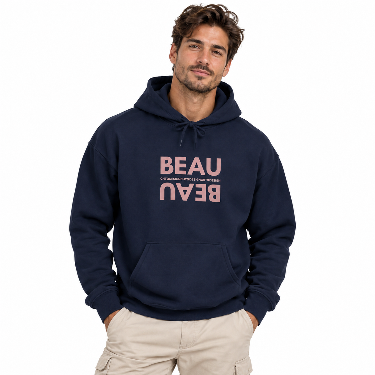 A man modeling a navy blue BEAU graphic hoodie with a mirrored dusty pink BEAU print and CHTQ Design detail on the chest, paired with beige pants against a white studio background.