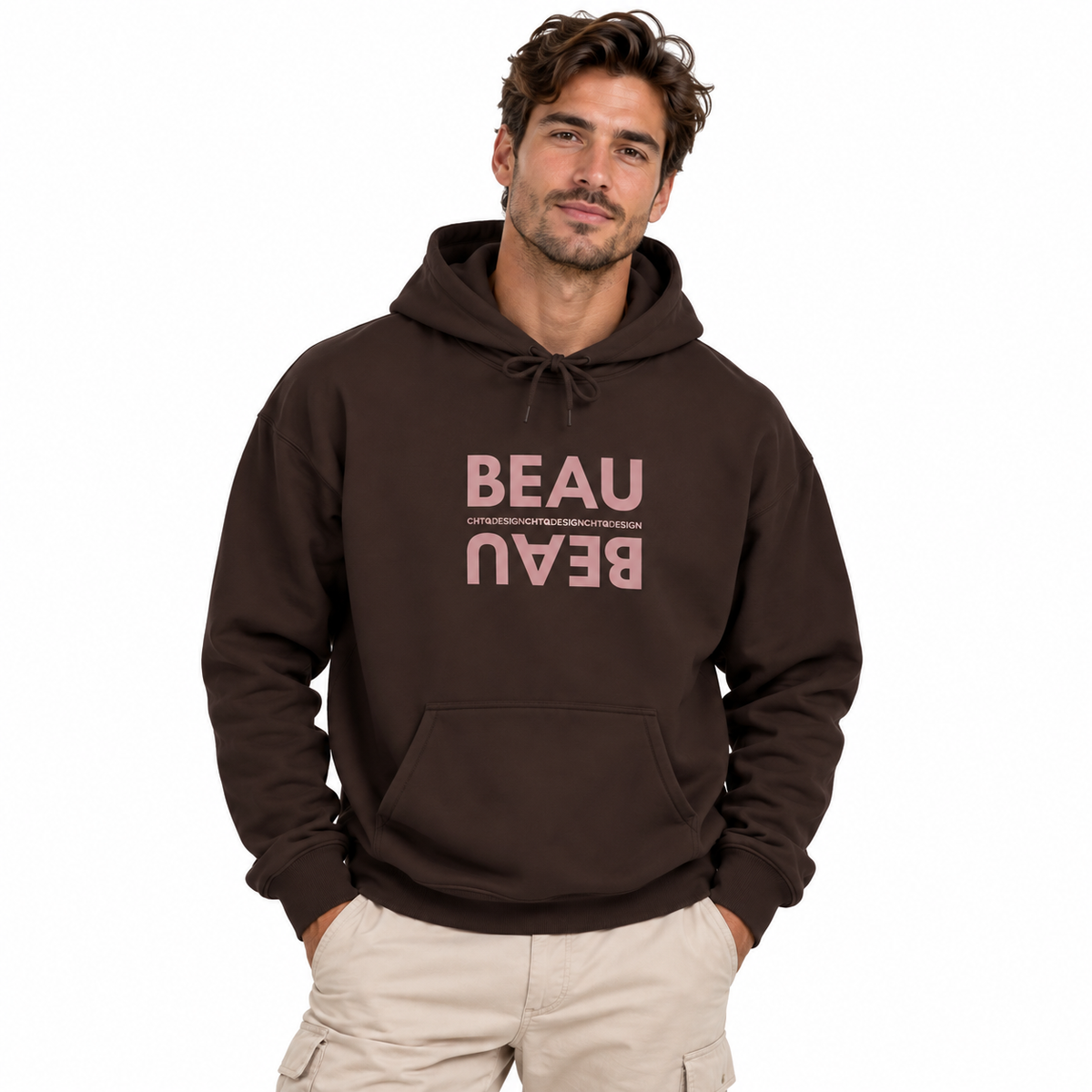 A man modeling a brown BEAU graphic hoodie with a mirrored dusty pink BEAU print and CHTQ Design detail on the chest, paired with beige pants against a white studio background.