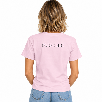 A woman viewed from behind wearing a light pink short-sleeve T-shirt with the words 'CODE CHIC' printed in black serif letters across the upper back, paired with light blue jeans against a plain white background.