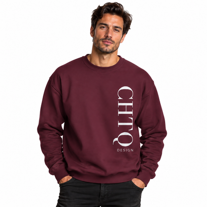 A man wearing a maroon-colored crewneck sweatshirt with a vertical white CHTQ DESIGN graphic on the front, paired with black jeans against a plain white studio background.