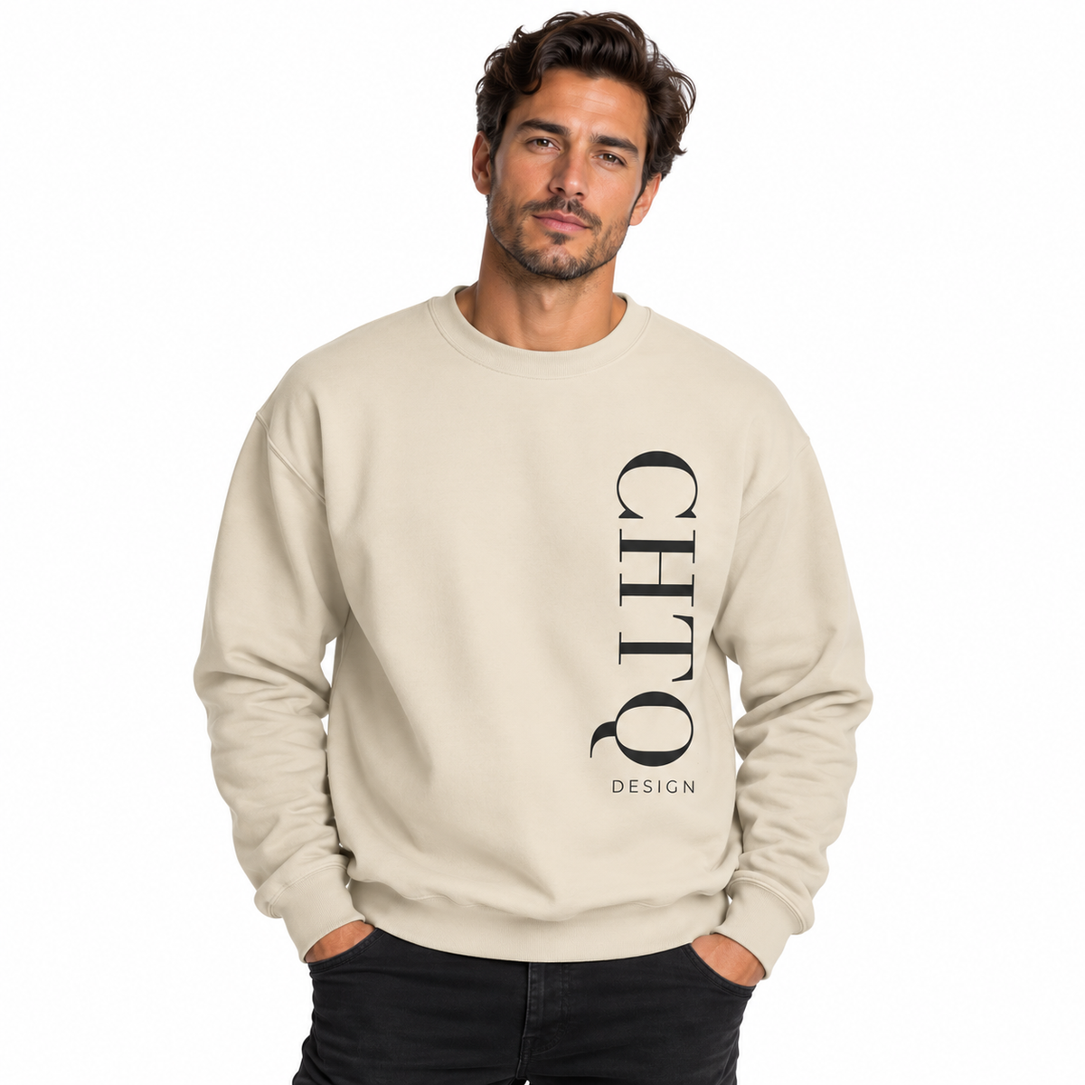 A man wearing a cream-colored crewneck sweatshirt with a vertical black CHTQ DESIGN graphic on the front, paired with black jeans against a plain white studio background.