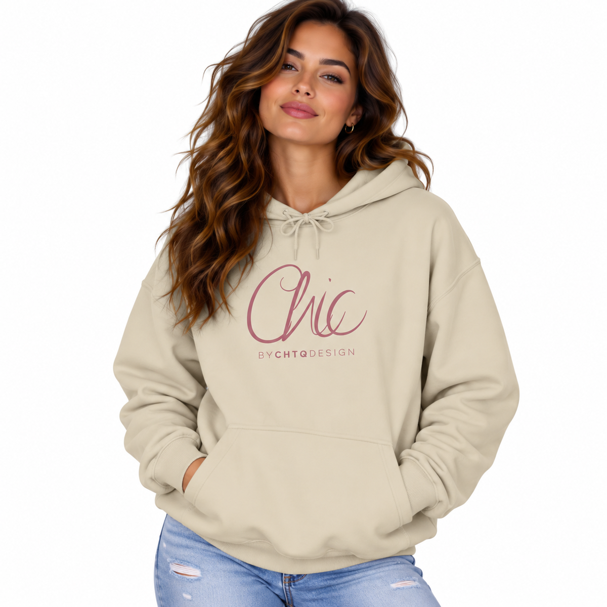 A woman wearing a beige pullover hoodie with a pink 'Chic by CHTQDESIGN' graphic on the chest, paired with light blue jeans, set against a plain white background.