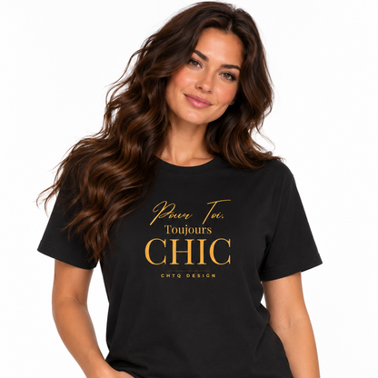 A woman with long wavy brown hair models a black short-sleeve t-shirt with gold printed text reading 'Pour Toi. Toujours CHIC CHTQ DESIGN' on the chest, paired with light blue jeans against a plain white background.
