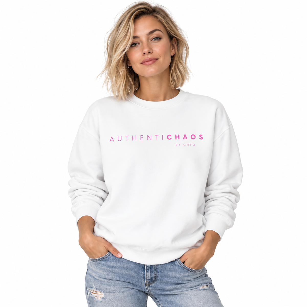 A woman wearing a white crewneck sweatshirt with 'AUTHENTICCHAOS BY CHTQ' printed in pink across the chest, paired with light-wash distressed jeans, set against a plain white background.