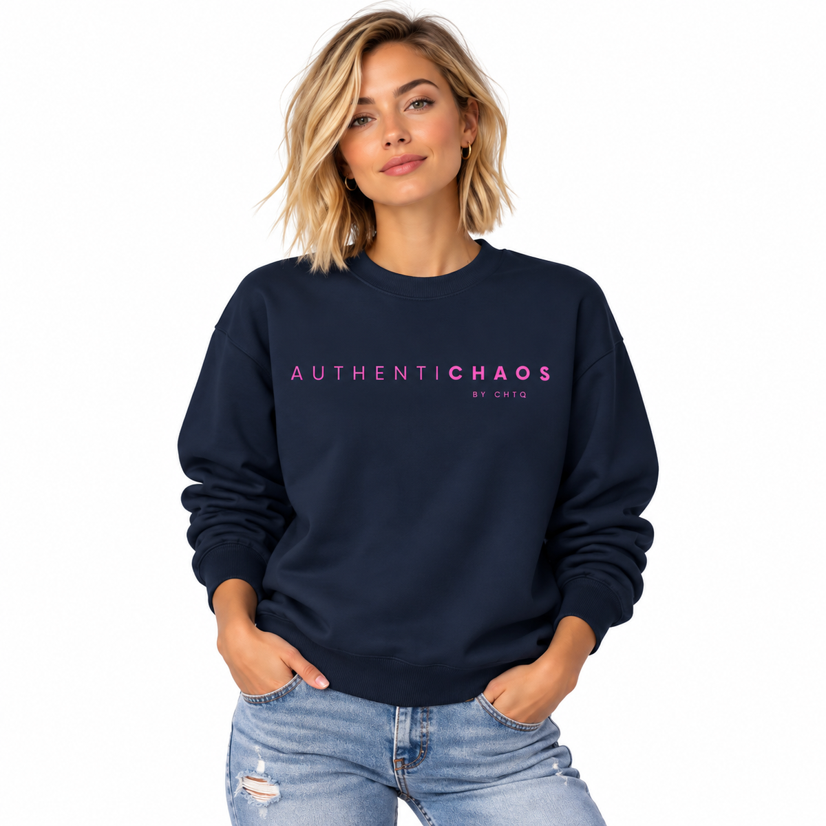 A woman wearing a navy blue crewneck sweatshirt with 'AUTHENTICCHAOS BY CHTQ' printed in pink across the chest, paired with light-wash distressed jeans, set against a plain white background.