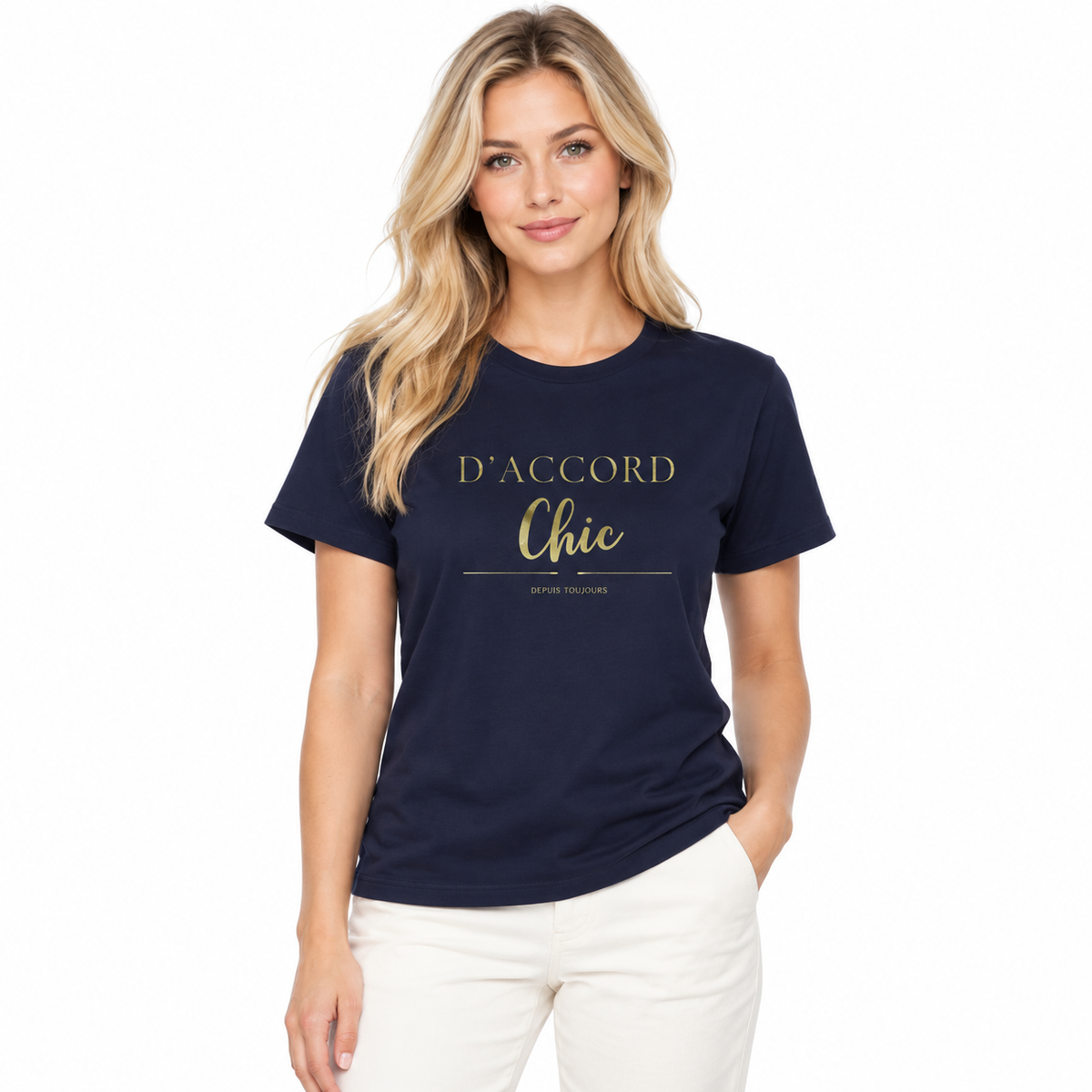 A woman modeling a navy blue short-sleeve t-shirt with gold printed text reading 'D'ACCORD Chic' and 'depuis toujours' on the front, paired with white pants against a plain white background.