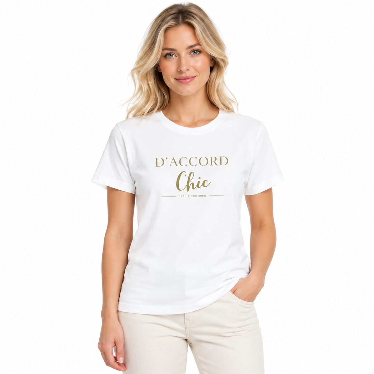 A woman modeling a white short-sleeve crewneck t-shirt with 'D'ACCORD Chic' printed in gold lettering on the chest, paired with light beige pants, against a plain white background.