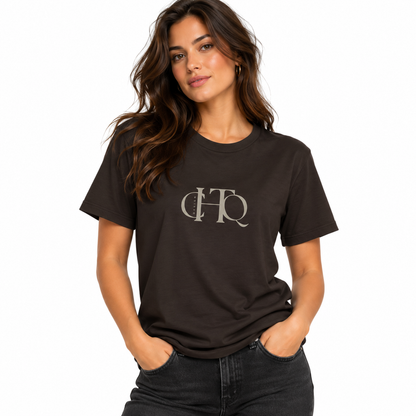 Woman wearing a dark chocolate CHTQ Design graphic T-shirt with minimalist front monogram