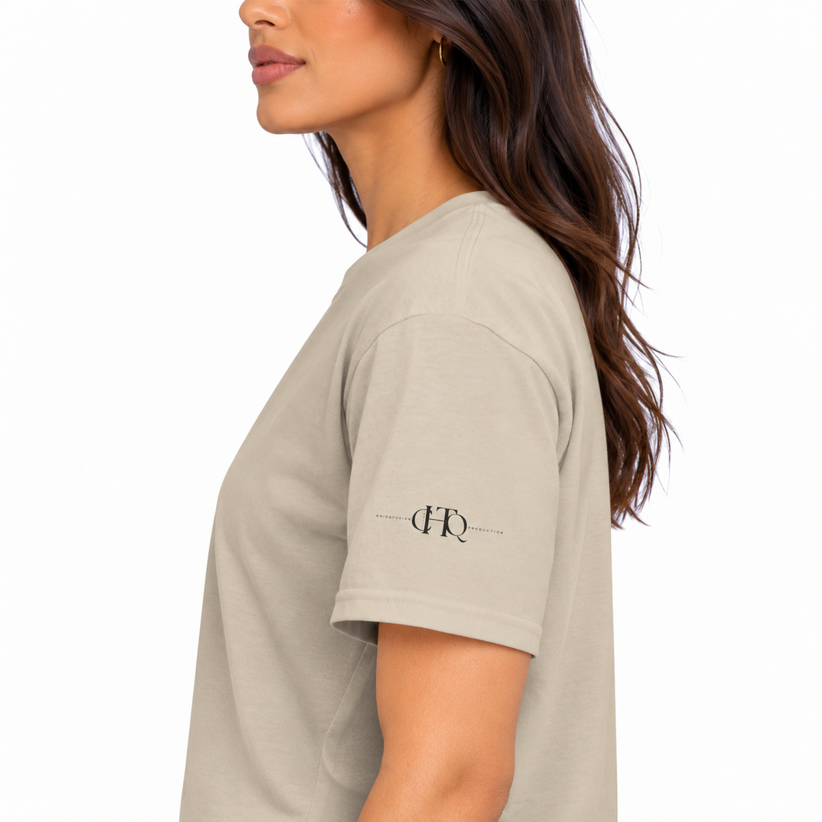 Close-up of sand CHAOTIQUE graphic T-shirt sleeve featuring a small CHTQ Design logo.