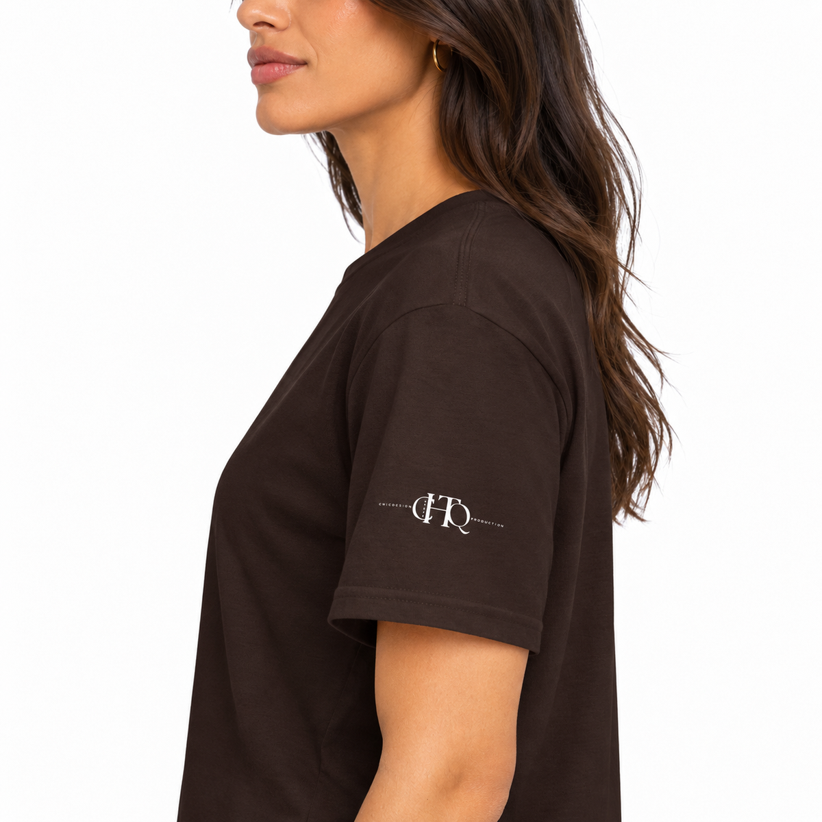 Close-up of dark chocolate brown CHAOTIQUE graphic T-shirt sleeve featuring a small CHTQ Design logo.