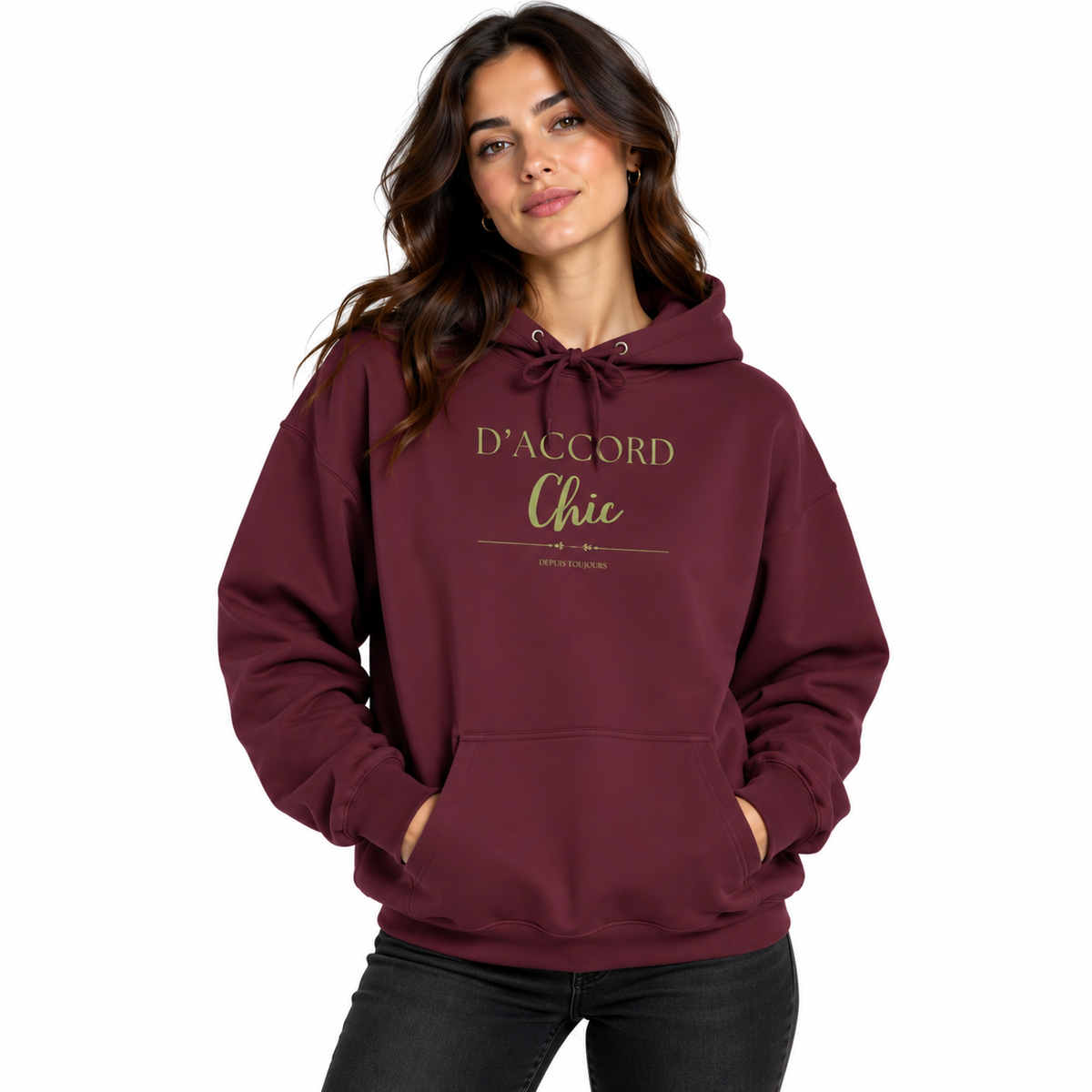A woman wearing a maroon pullover hoodie with 'D'ACCORD Chic' printed in gold on the chest, paired with black jeans, against a plain white background.