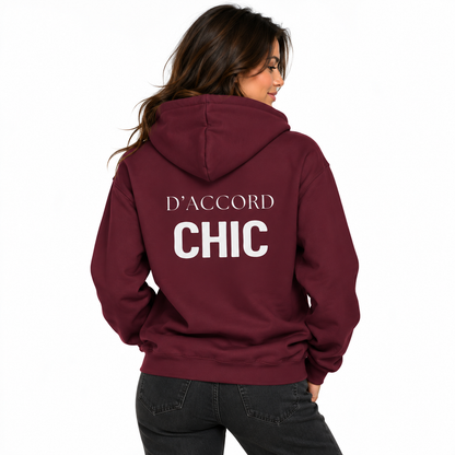 A woman shown from the back wearing a maroon hoodie with 'D'ACCORD CHIC' printed in white across the back, paired with dark gray jeans, against a plain white background.