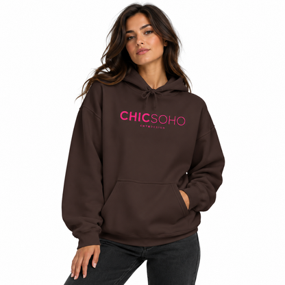 A woman wearing a dark brown pullover hoodie with 'CHICSOHO' printed in pink across the chest, paired with dark gray jeans, set against a plain white background.