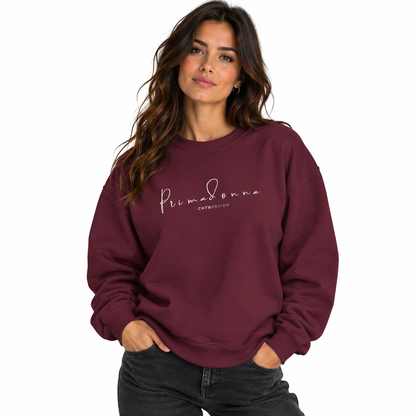 A woman wearing PRIMADONNA by CHTQ Design maroon crewneck sweatshirt featuring elegant light-colored handwritten lettering on the chest, front view on white background.