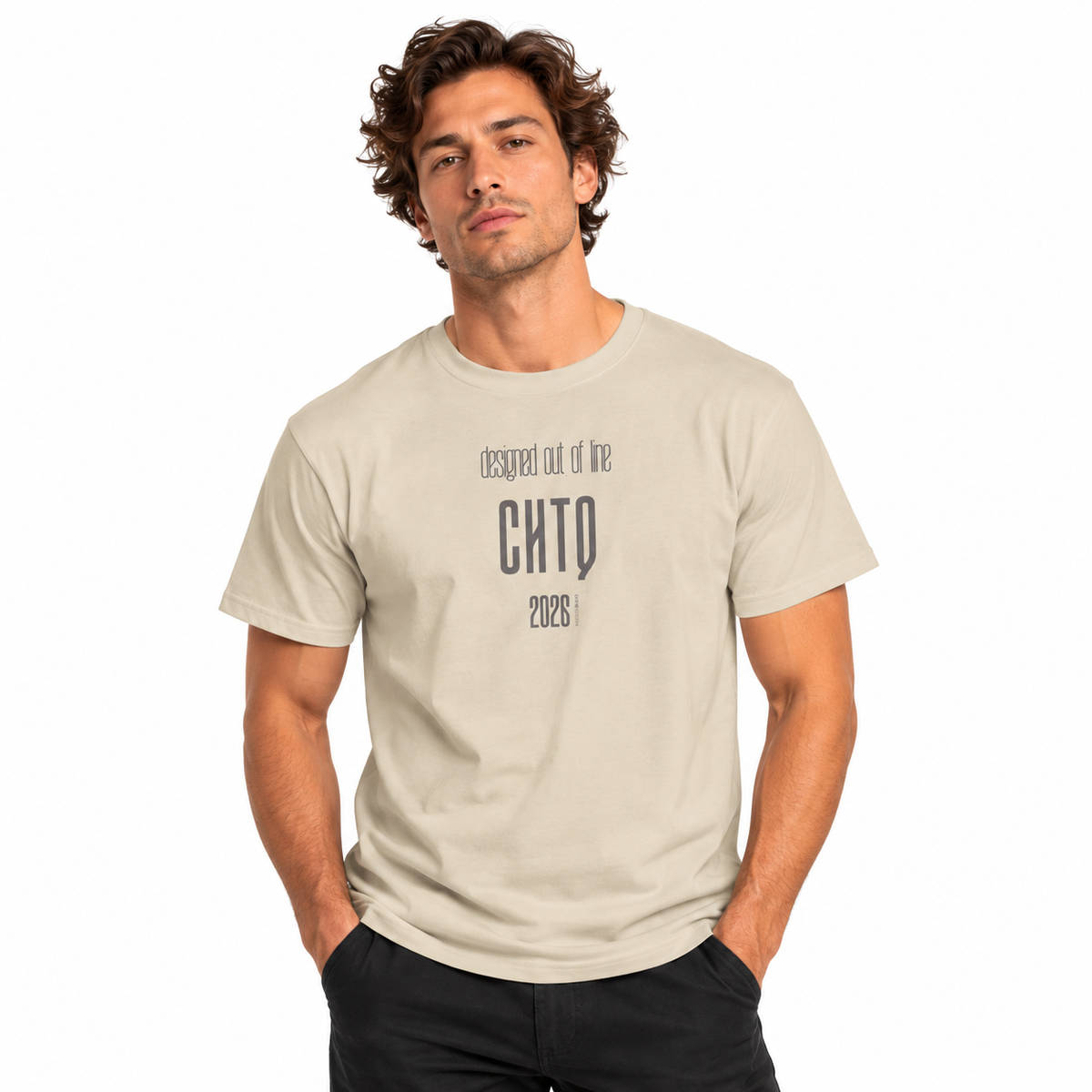 Male model wearing a sand-colored Designed Out of Line CHTQ Graphic T-Shirt with gray typography, paired with black trousers against a white studio background.
