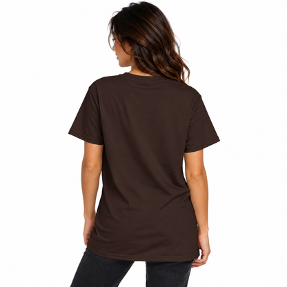 Back view of a female model wearing a chocolate brown UNSNAKEBLY T-shirt with a long relaxed fit and dark jeans.