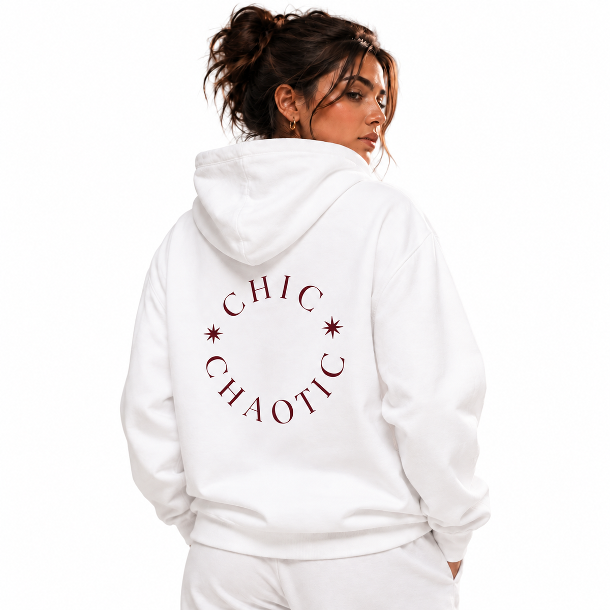 A woman shown from the back wearing a white hoodie with a dark red circular graphic that reads 'CHIC CHAOTIC' and small star accents, against a plain white background.