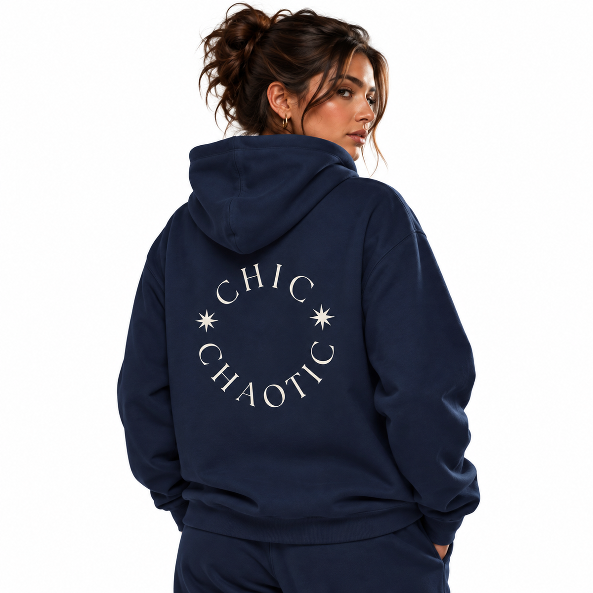 A woman shown from the back wearing a navy blue hoodie with a white circular graphic that reads 'CHIC CHAOTIC' and small starburst details. The photo is shot against a clean white background.
