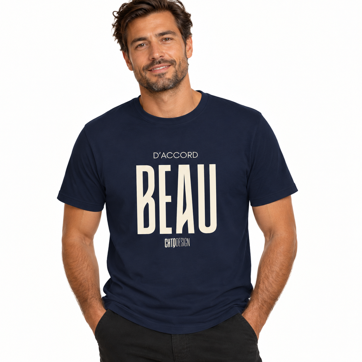 A man wearing a navy blue crewneck t-shirt with a large cream-colored graphic print on the front that reads 'D'ACCORD BEAU'.