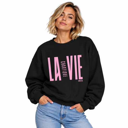 Woman wearing black LA VIE CHAOTIQUE by CHTQ Design sweatshirt with light pink graphic