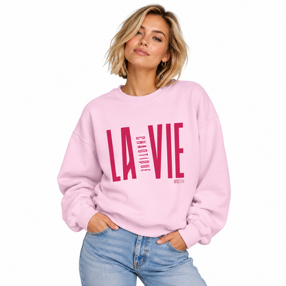 Woman wearing light pink LA VIE CHAOTIQUE crewneck sweatshirt with magenta graphic