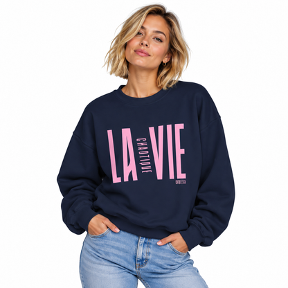 Woman wearing navy LA VIE CHAOTIQUE by CHTQ Design crewneck sweatshirt with light pink graphic