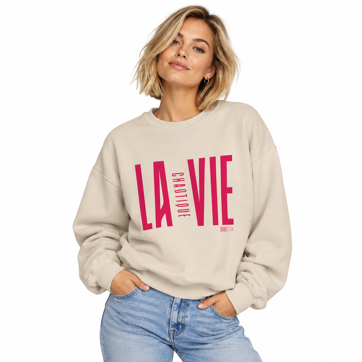 Woman wearing sand LA VIE CHAOTIQUE crewneck sweatshirt with vibrant magenta graphic