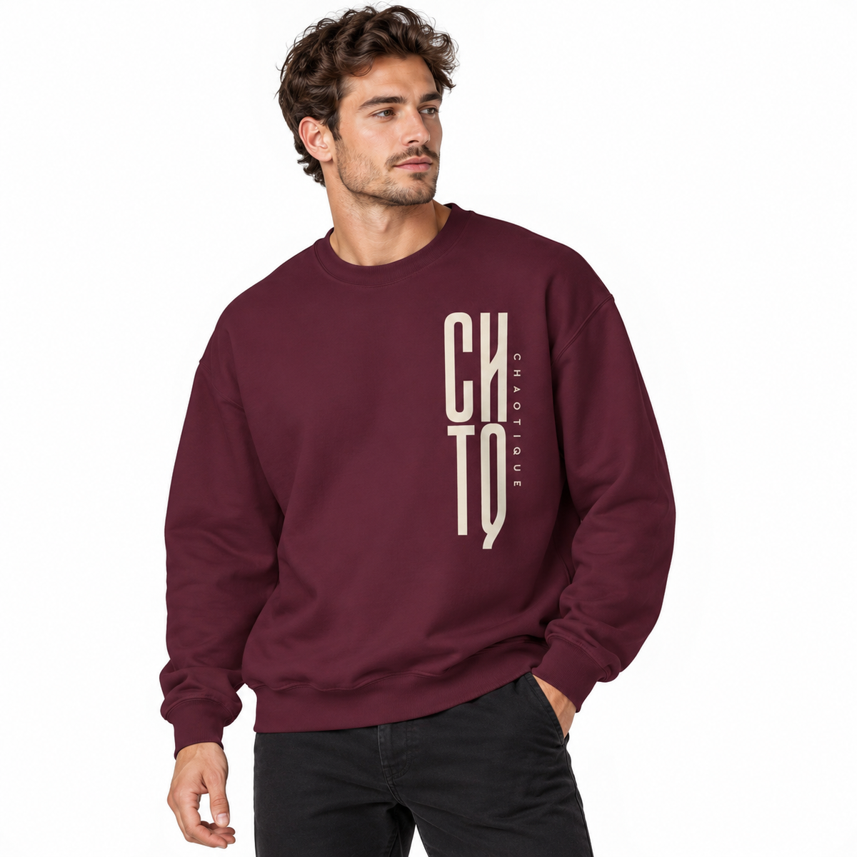 Male model wearing a maroon CHTQ CHAOTIQUE men's crewneck sweatshirt with vertical CHTQ graphic and CHAOTIQUE lettering, front view on a white studio background.