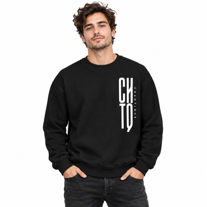Male model wearing a black CHTQ CHAOTIQUE men's crewneck sweatshirt with a bold vertical white CHTQ graphic and CHAOTIQUE lettering, front view in a white studio.