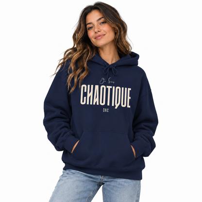 Woman modeling a navy blue Je Suis CHAOTIQUE CHIC graphic hoodie with light cream lettering, paired with light blue jeans.
