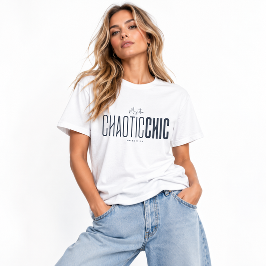 Blonde woman wearing a white Magnetic CHAOTICCHIC graphic T-shirt with dark navy lettering and relaxed light blue jeans in a white studio.