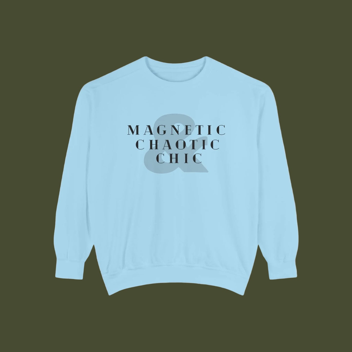 A light blue crewneck sweatshirt with a graphic on the chest featuring the text 'MAGNETIC CHAOTIC CHIC' in black serif font over a gray ampersand symbol.