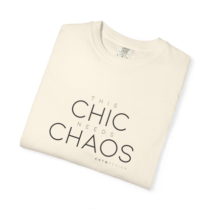 A folded cream-colored t-shirt with black text reading 'THIS CHIC NEEDS CHAOS' and 'CHTCODESIGN' printed below, displayed on a clean white background.