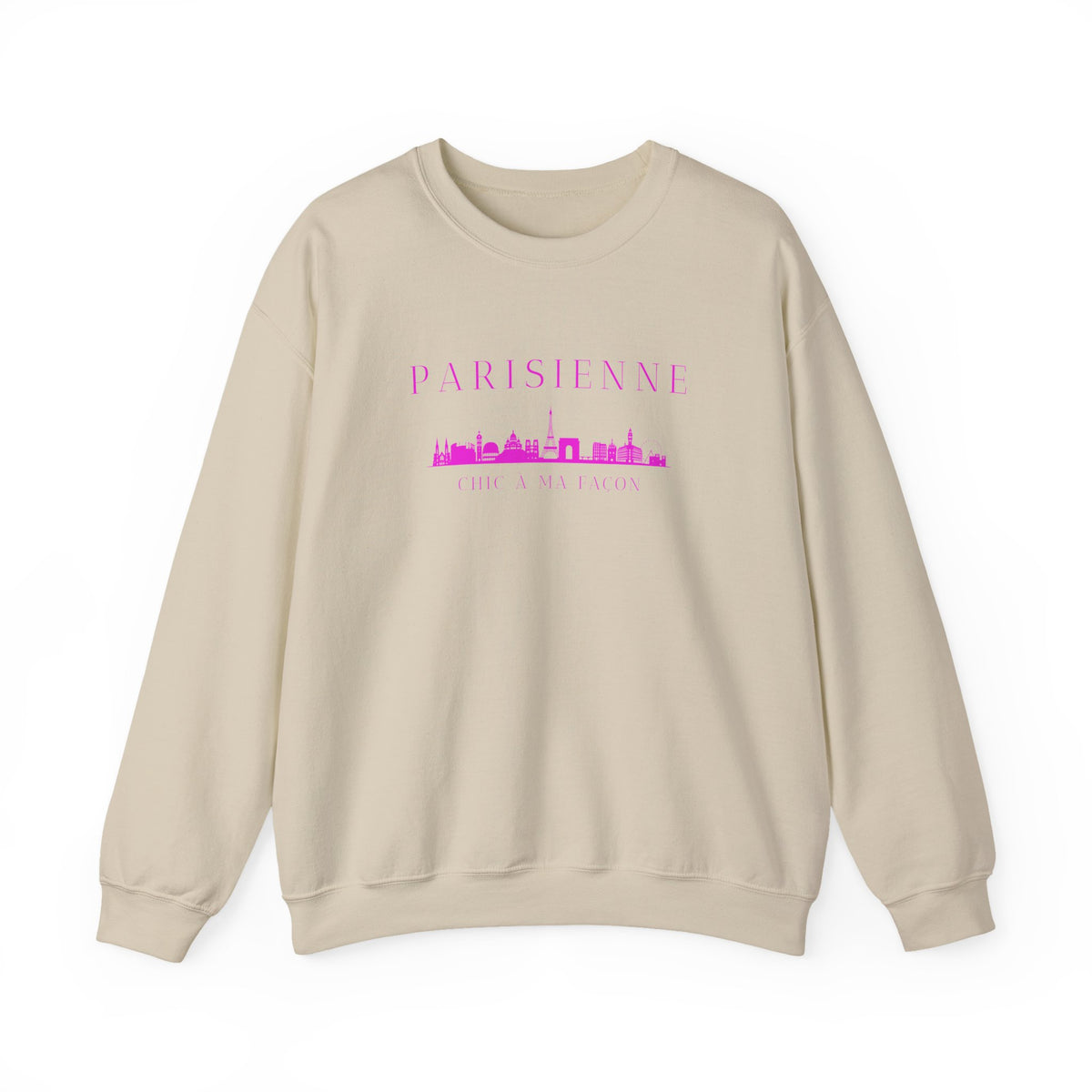 A beige crewneck sweatshirt with a bright pink “PARISIENNE” graphic, Paris skyline design, and “CHIC À MA FAÇON” text on the chest, displayed against a clean white background.