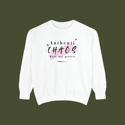 A white crewneck sweatshirt with a graphic print on the chest that reads 'Authenti CHAOS Real, not perfect.' in black text over a light pink paint stroke, displayed on a clean white background.