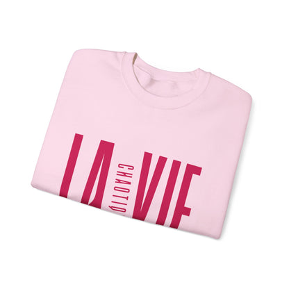 Folded light pink LA VIE CHAOTIQUE sweatshirt showing magenta typography