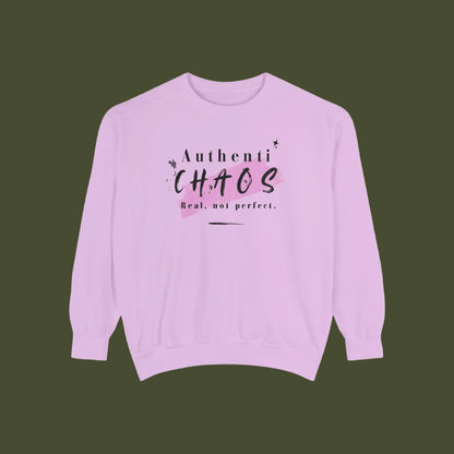 A light purple crewneck sweatshirt with a graphic on the chest that reads 'Authenti CHAOS Real, not perfect.' in black and pink lettering, displayed on a solid white background.