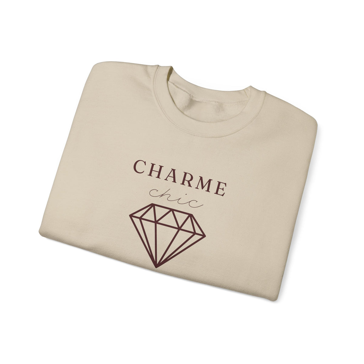 A folded beige crewneck sweatshirt featuring a burgundy graphic print that reads 'CHARME chic' above a diamond outline, set against a plain white background.