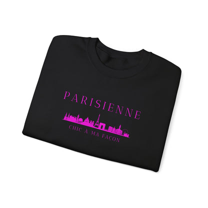 A folded black crewneck sweatshirt with a bright pink “PARISIENNE” graphic, Paris skyline design, and “CHIC À MA FAÇON” text on the chest, displayed against a clean white background.