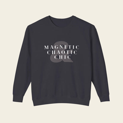 A dark navy crewneck sweatshirt with the phrase 'Magnetic Chaotic Chic' printed in white distressed capital letters across the chest