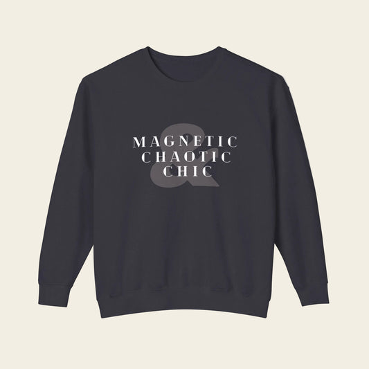 A dark navy crewneck sweatshirt with the phrase 'Magnetic Chaotic Chic' printed in white distressed capital letters across the chest