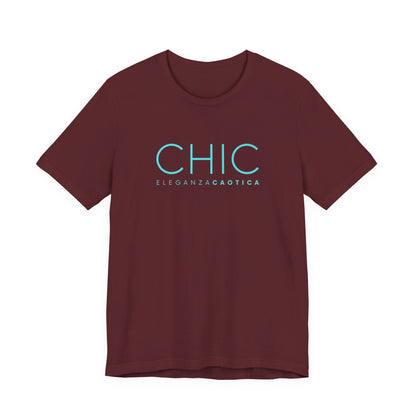Maroon graphic T-shirt with pink 'CHIC ELEGANZA CAOTICA' typography on a neutral gray studio background.