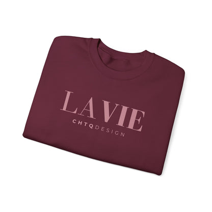 A folded maroon crewneck t-shirt with 'LA VIE' and 'CHTQDESIGN' printed in light pink on the front, displayed on a clean white background.