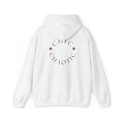 A white pullover hoodie shown from the back, featuring a circular graphic with the text 'CHIC CHAOTIC' and small star accents in a muted plum-brown color.