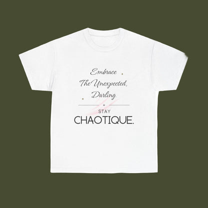 A white short-sleeve crewneck t-shirt with a typographic graphic on the front. The design features the phrase 'Embrace The Unexpected, Darling' in a cursive font, a thin horizontal line, the word 'STAY' in a block font, and 'CHAOTIQUE.