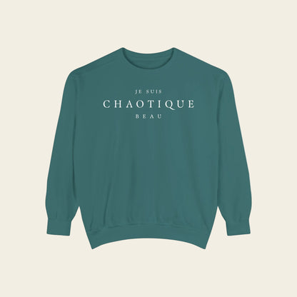 Teal sweatshirt with 'Je Suis Chaotique Beau' text on a white background