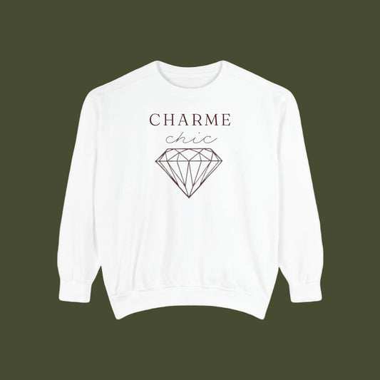 A white crewneck sweatshirt featuring a graphic print on the front with the text 'CHARME chic' and a black line art diamond illustration, displayed against a solid white background.