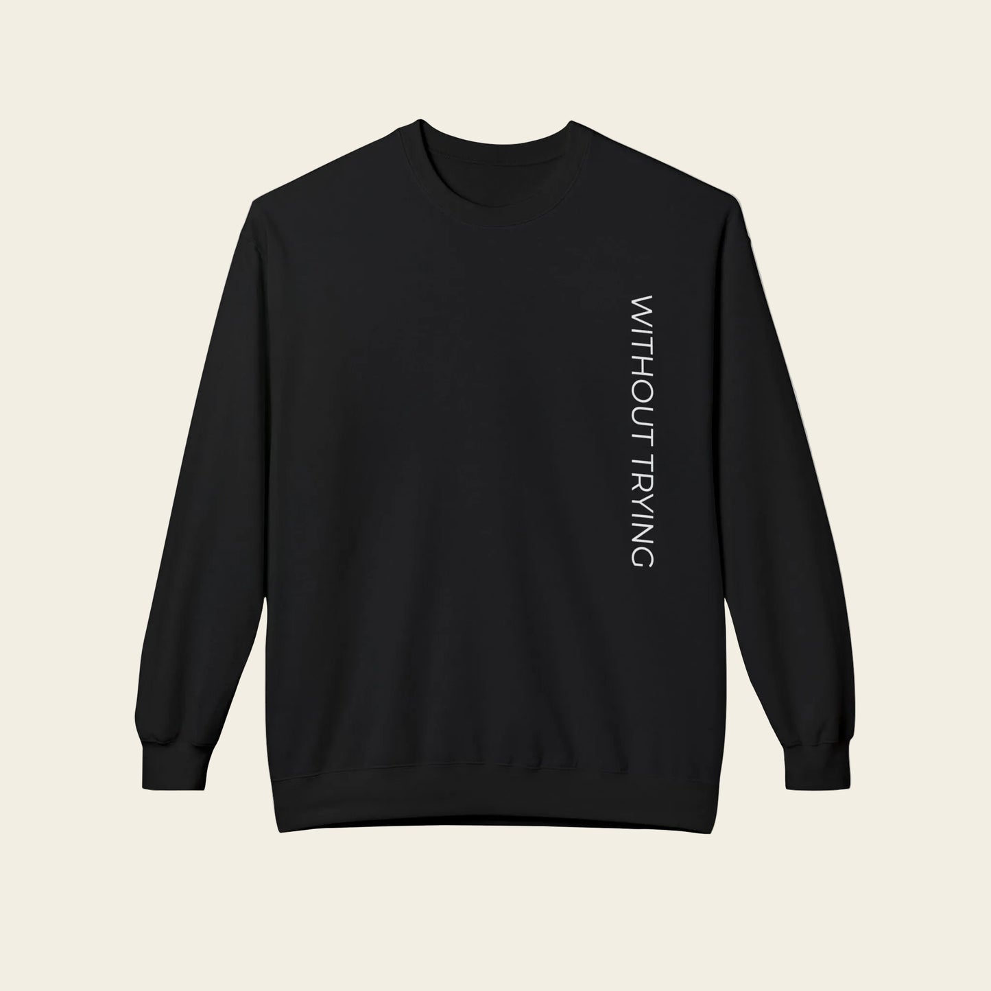 A black crewneck sweatshirt featuring a detailed black and white graphic print of a classic English manor house by a lake, with the word 'without trying' printed below the illustration.